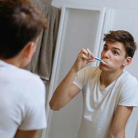 Teen brushing their teeth in bathroom